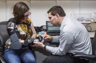 A fabricante de robótica médica Myomo Inc. completou sua oferta pública inicial. Jessica Peters, uma sobrevivente de acidente vascular cerebral, é mostrada testando um dos produtos da empresa com Gene Tacy, vice-presidente de engenharia da Myomo, em Cambridge, Massachusetts. Foto: Bob O